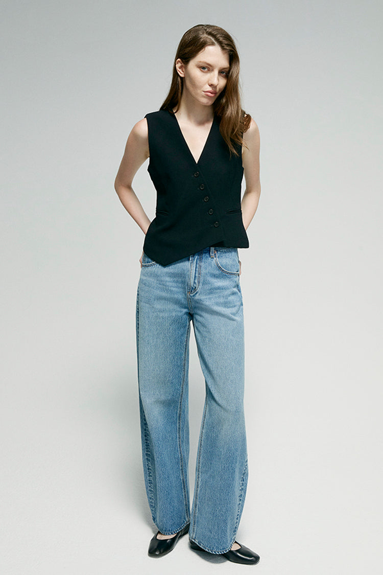 Woman wearing a black sleeveless top and blue jeans on a white background