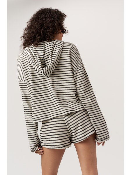 Person wearing a black and white striped outfit on a plain background