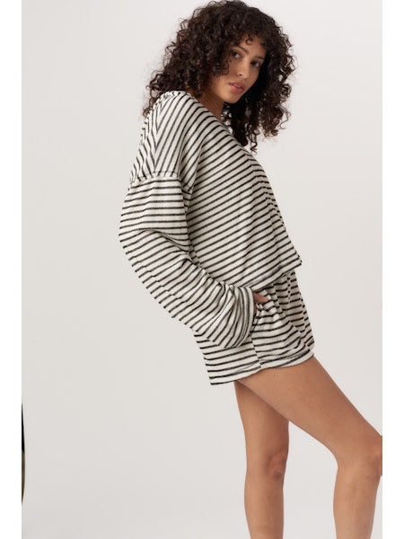 Woman wearing a black and white striped outfit on a plain background