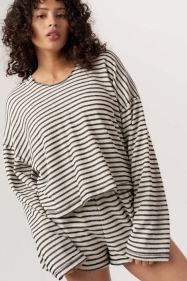 Woman wearing a black and white striped outfit on a plain background