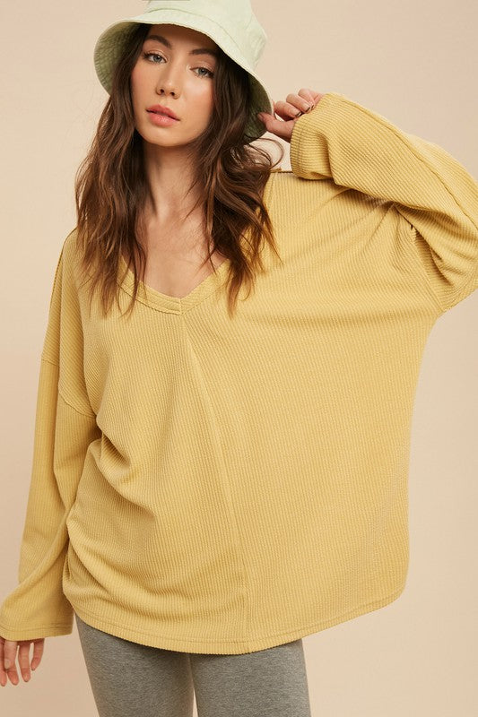 Cozy oversized Cassie Top with v-neckline, raglan sleeves, and exposed seam detail in soft polyester-rayon-spandex blend