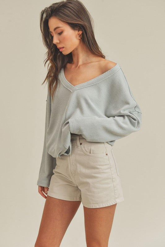 Cozy oversized Cassie Top with v-neckline, raglan sleeves, and exposed seam detail in soft polyester-rayon-spandex blend