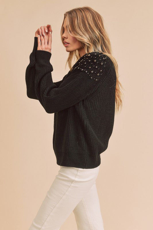 Side view of the Sylvia Embellished Shoulder Sweater in black worn by a model 