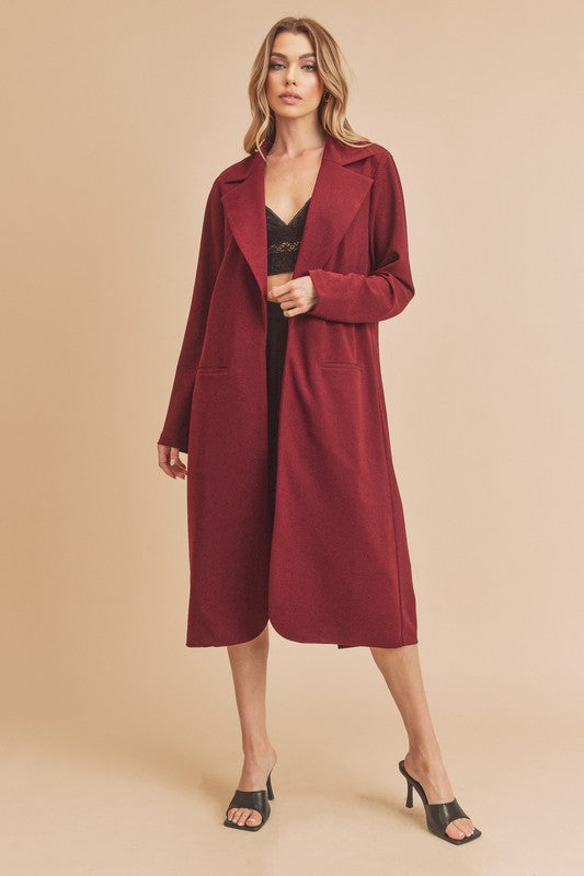 Model wearing burgundy longline knit coat, with black lace top underneath