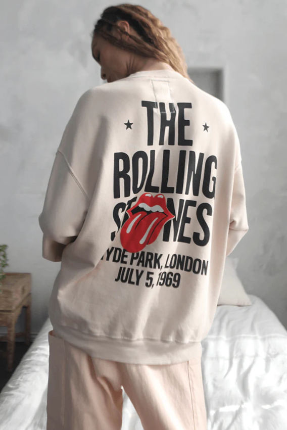 Person wearing a 'The Rolling Stones' shirt with a graphic design in a bedroom setting.