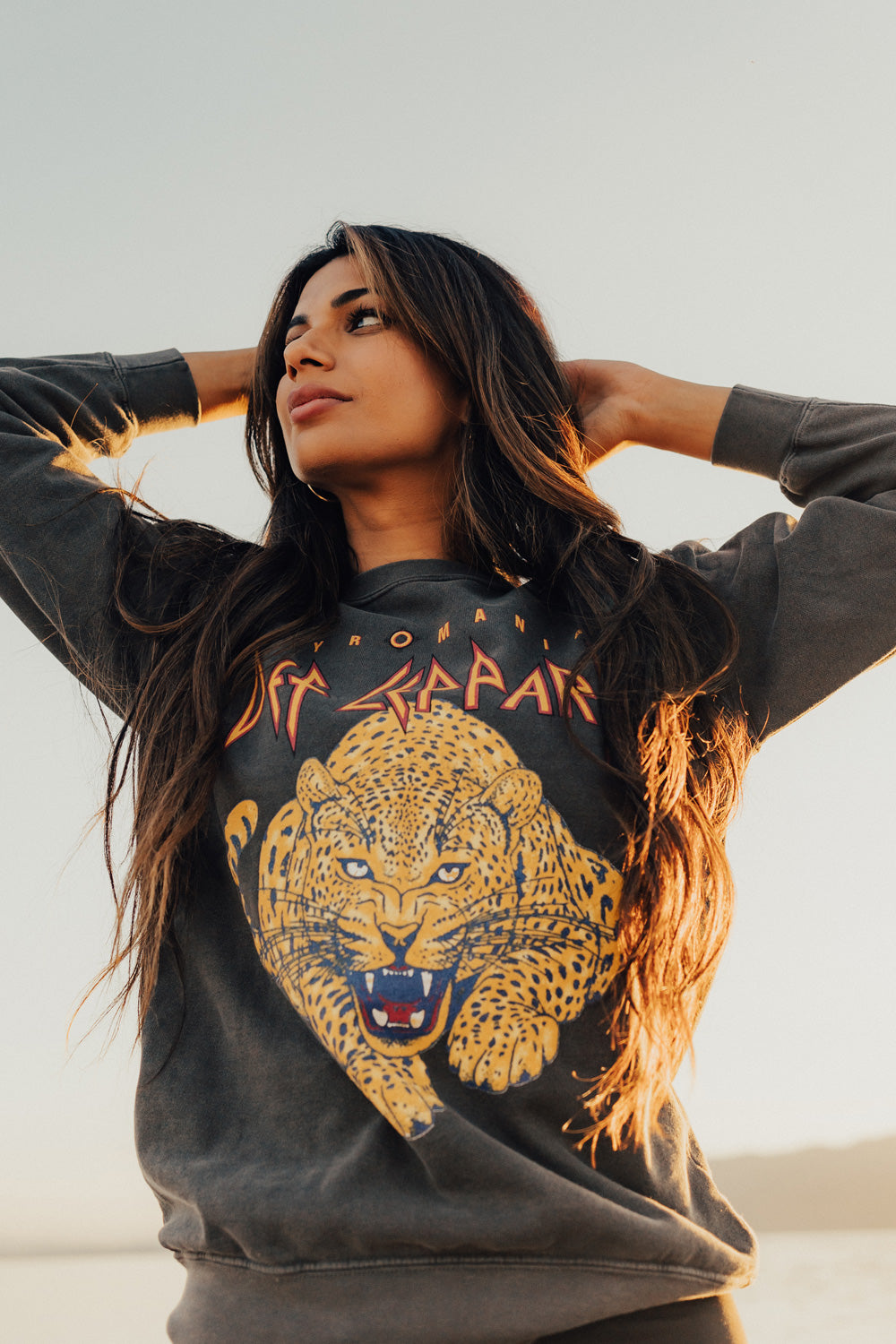 Woman wearing a black sweatshirt with a yellow panther graphic and text.