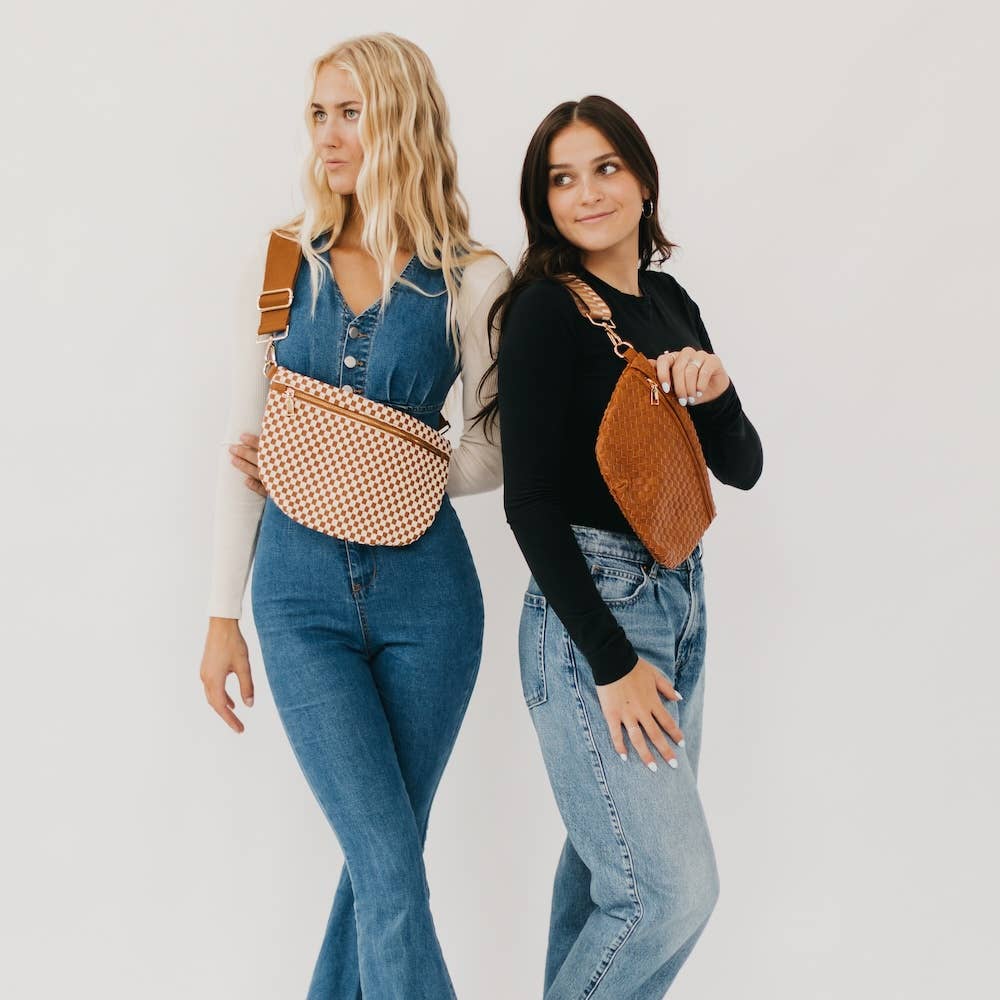 Two women holding handbags against a plain background