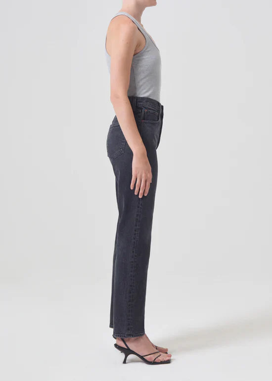 Side view showing the Agolde Stovepipe jeans in "Metal" paired with a casual top, highlighting the flattering high-rise and straight leg silhouette.