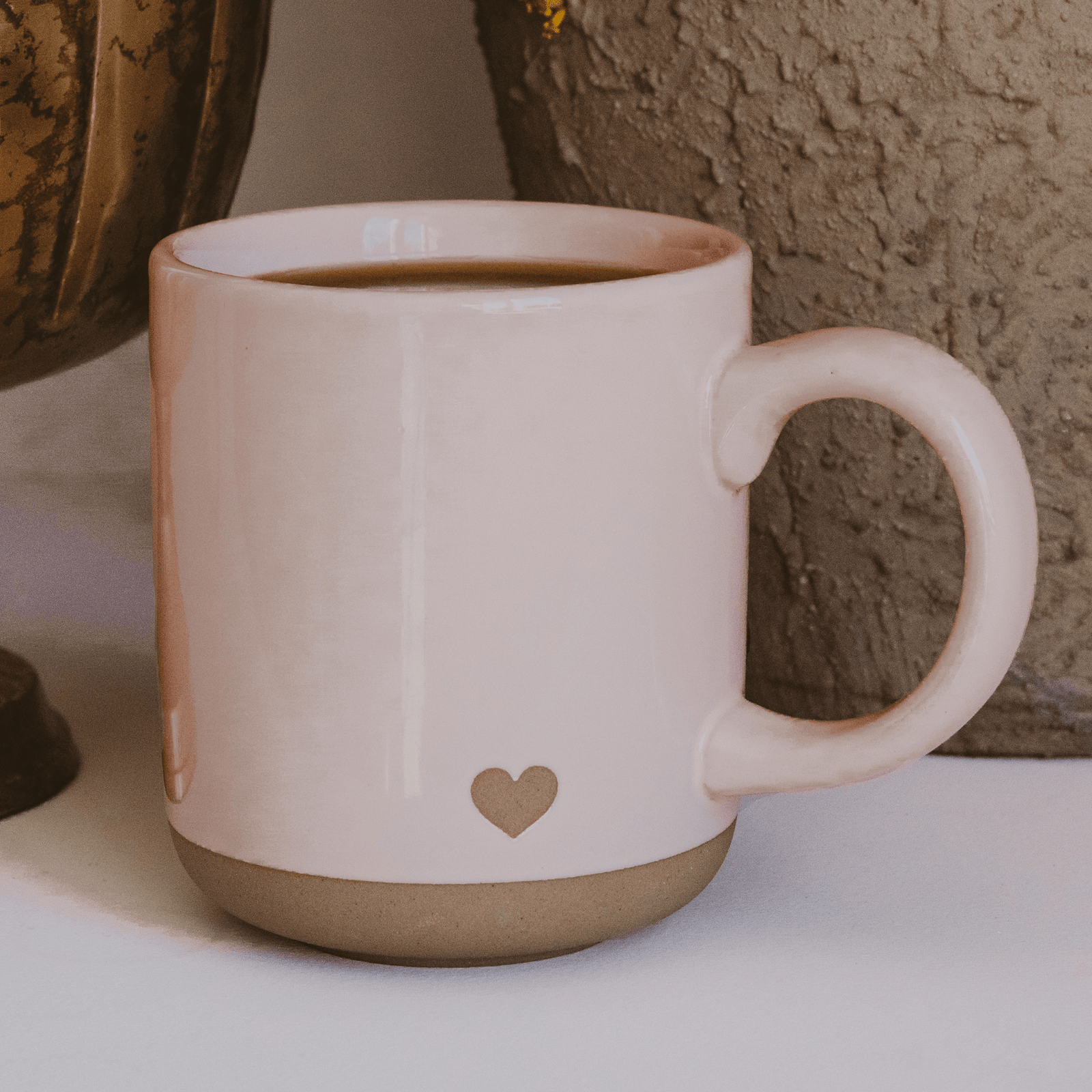 Pink mug with a heart design on a neutral background