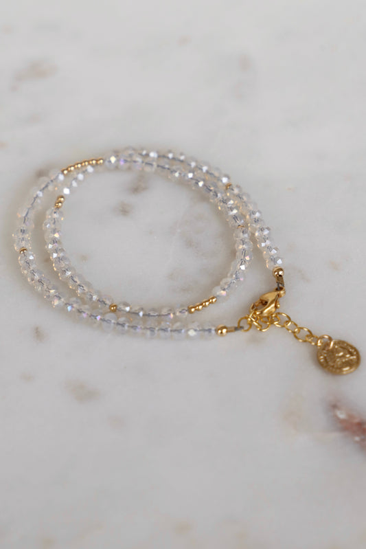 double wrap beaded bracelet with gold clasps on a marble surface