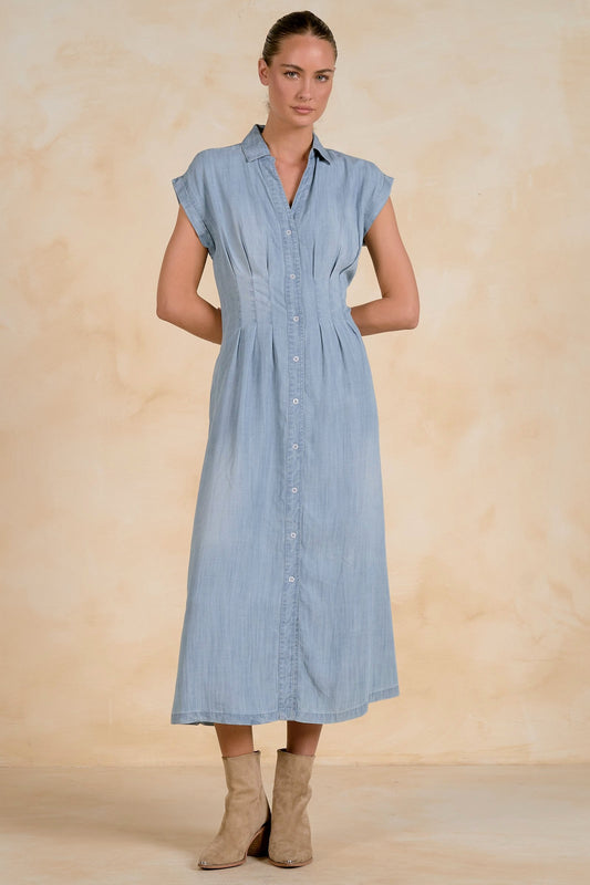Woman wearing a light blue dress against a beige background