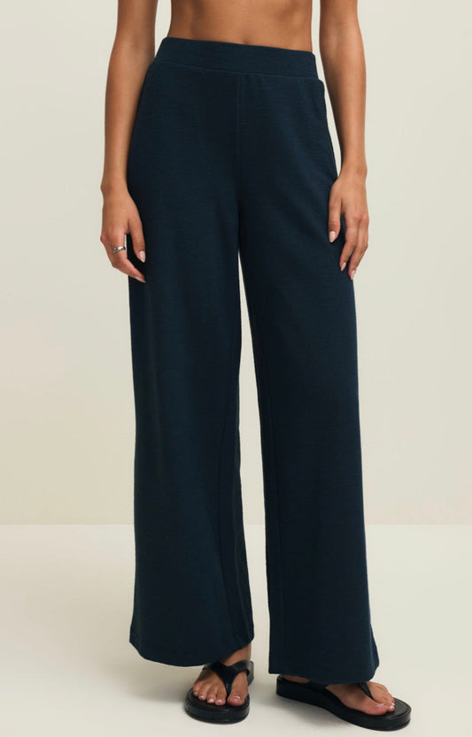 Navy blue wide-leg pants worn by a person on a plain background
