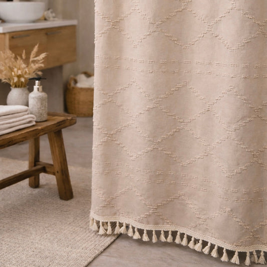 Beige textured shower curtain with tassels in a bathroom setting