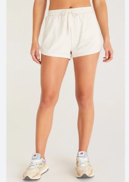 Person wearing white shorts on a plain background