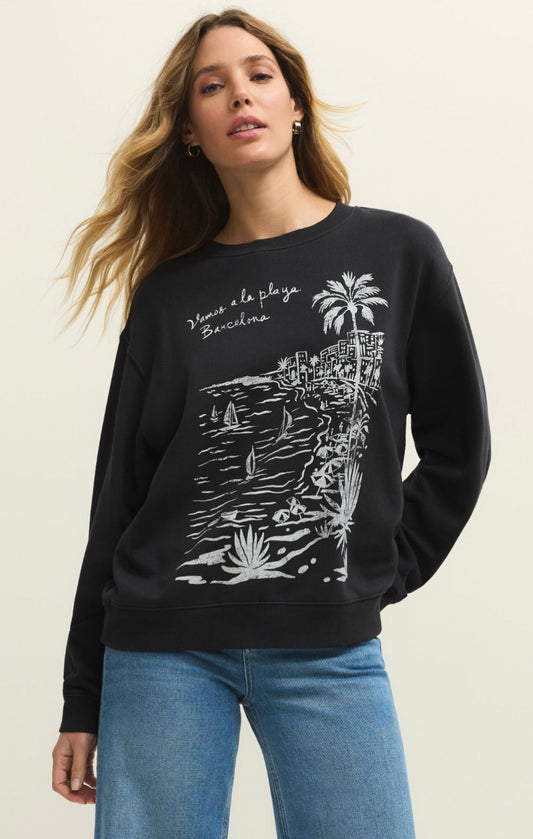Woman wearing a black sweatshirt with white graphics and text, standing against a plain background