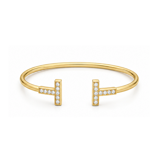 Gold bracelet with 'H' and diamond accents on a white background