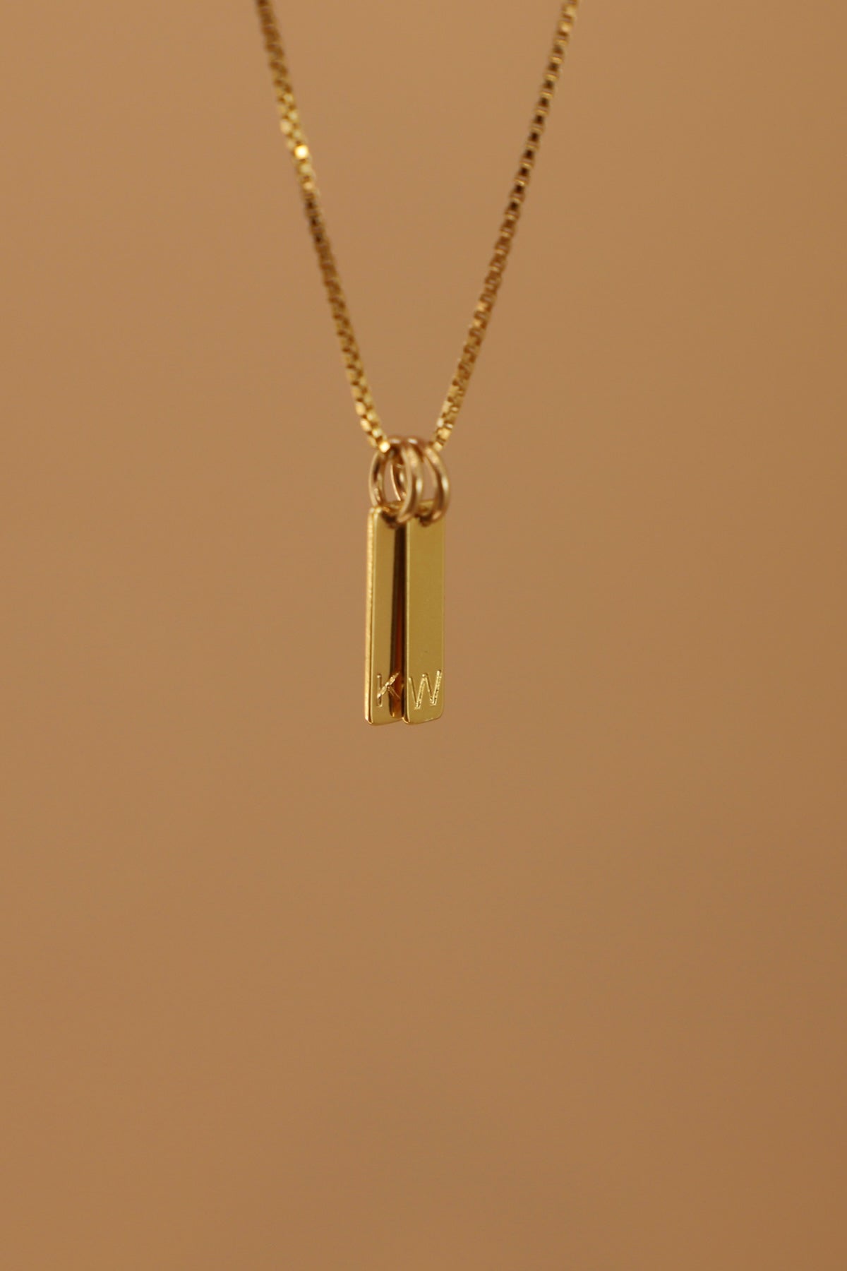 Gold necklace with a pendant on a brown background