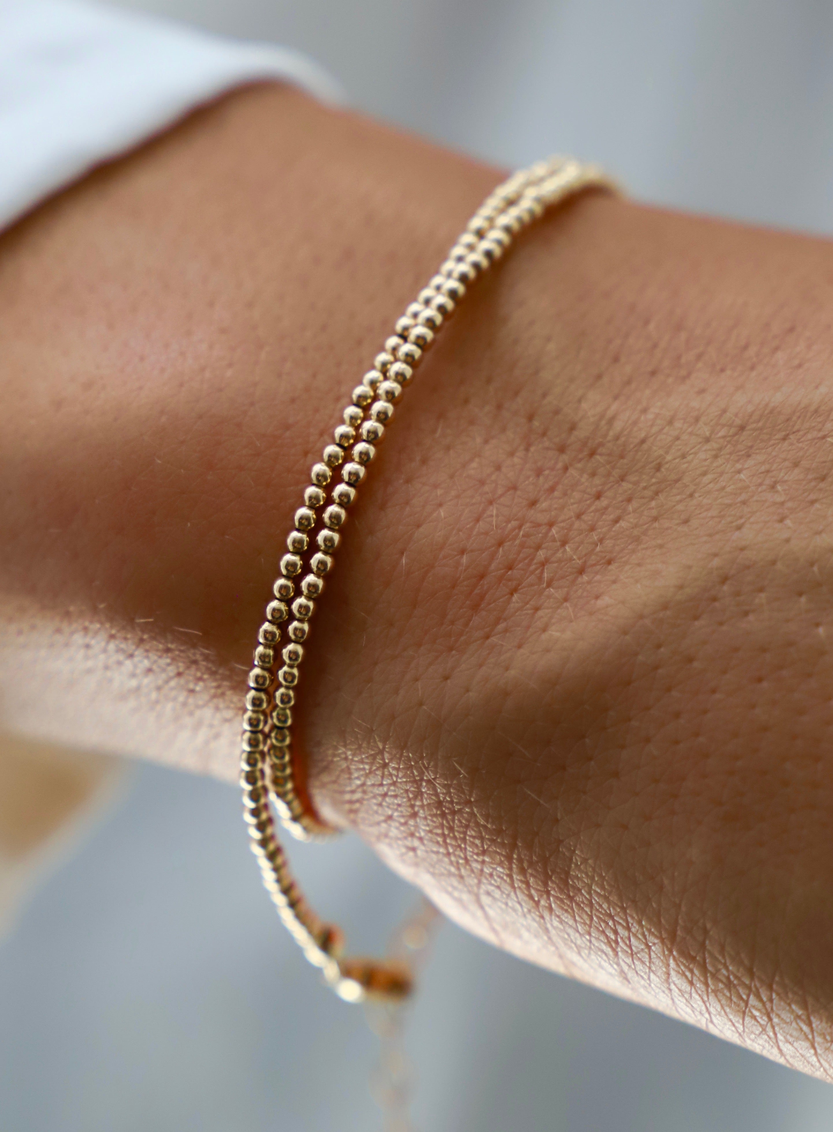 Double wrap beaded bracelet in gold filled design – versatile jewelry worn as bracelet or choker necklace, dainty everyday accessory pictured on a wrist
