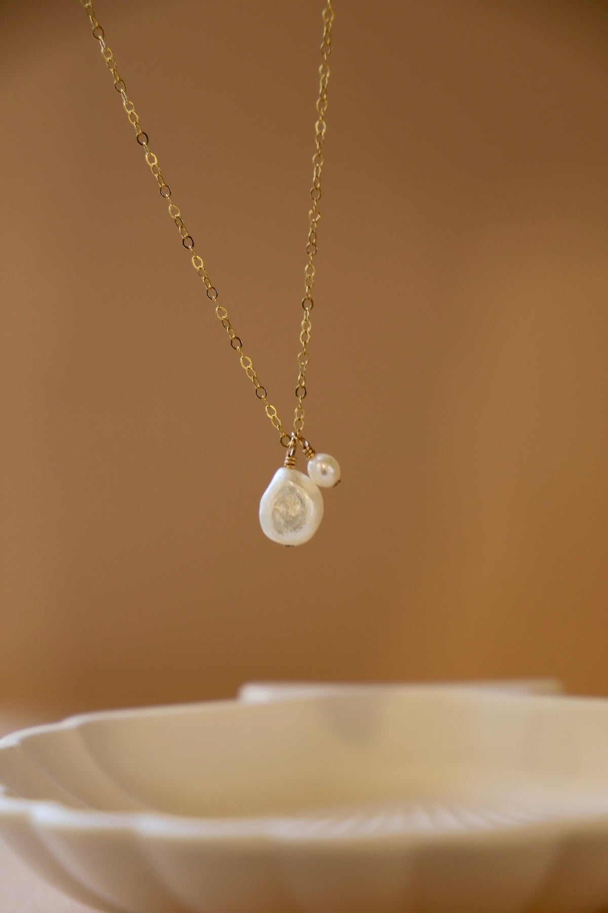 Gold necklace with pearl pendants on a blurred background