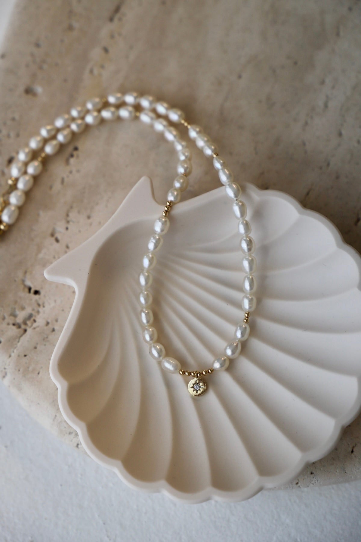 Pearl necklace with a gold clasp on a seashell