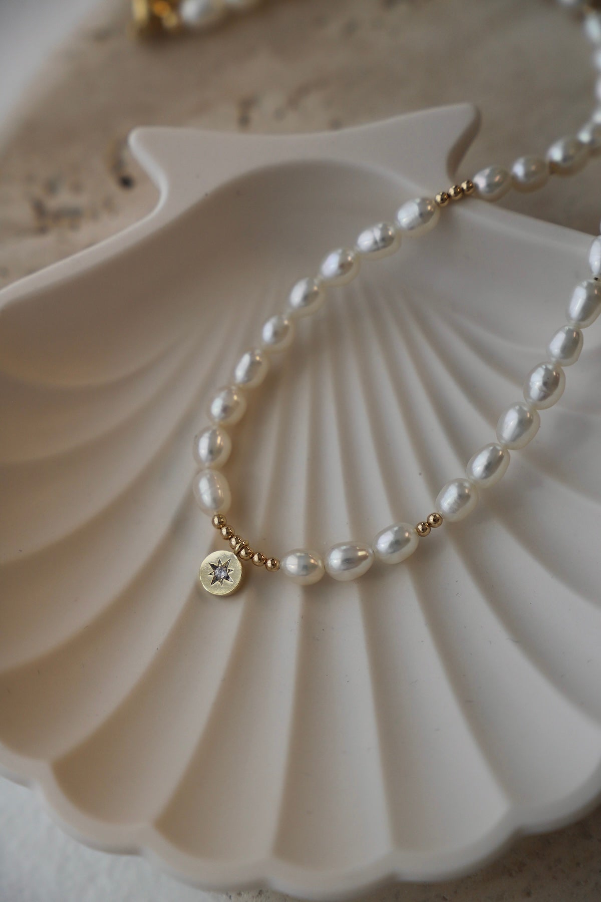 Pearl bracelet with a gold clasp on a white shell