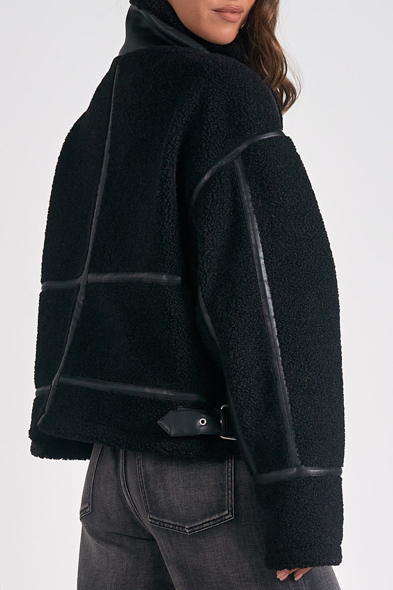 Black textured jacket worn by a person on a white background