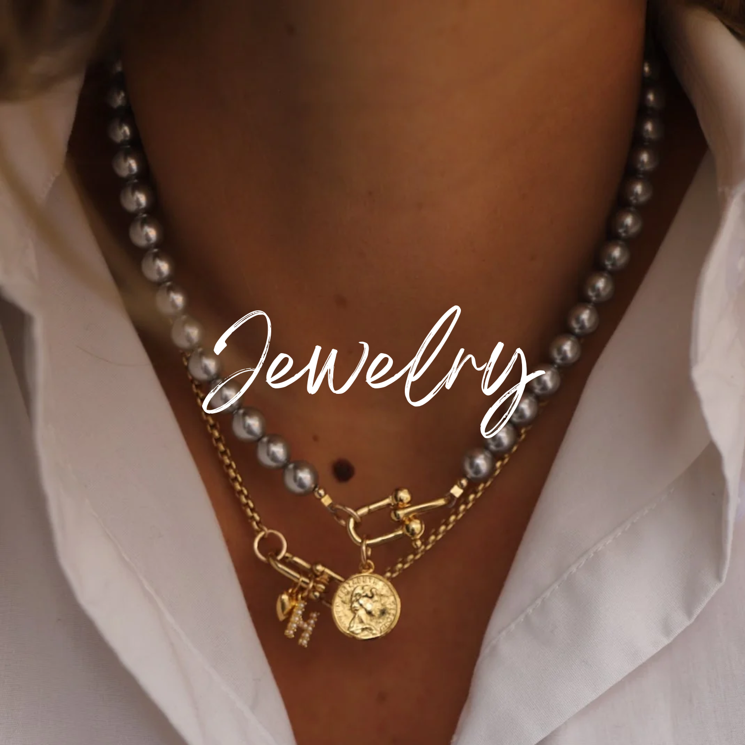 Close-up of a person wearing layered necklaces and earrings with a neutral background