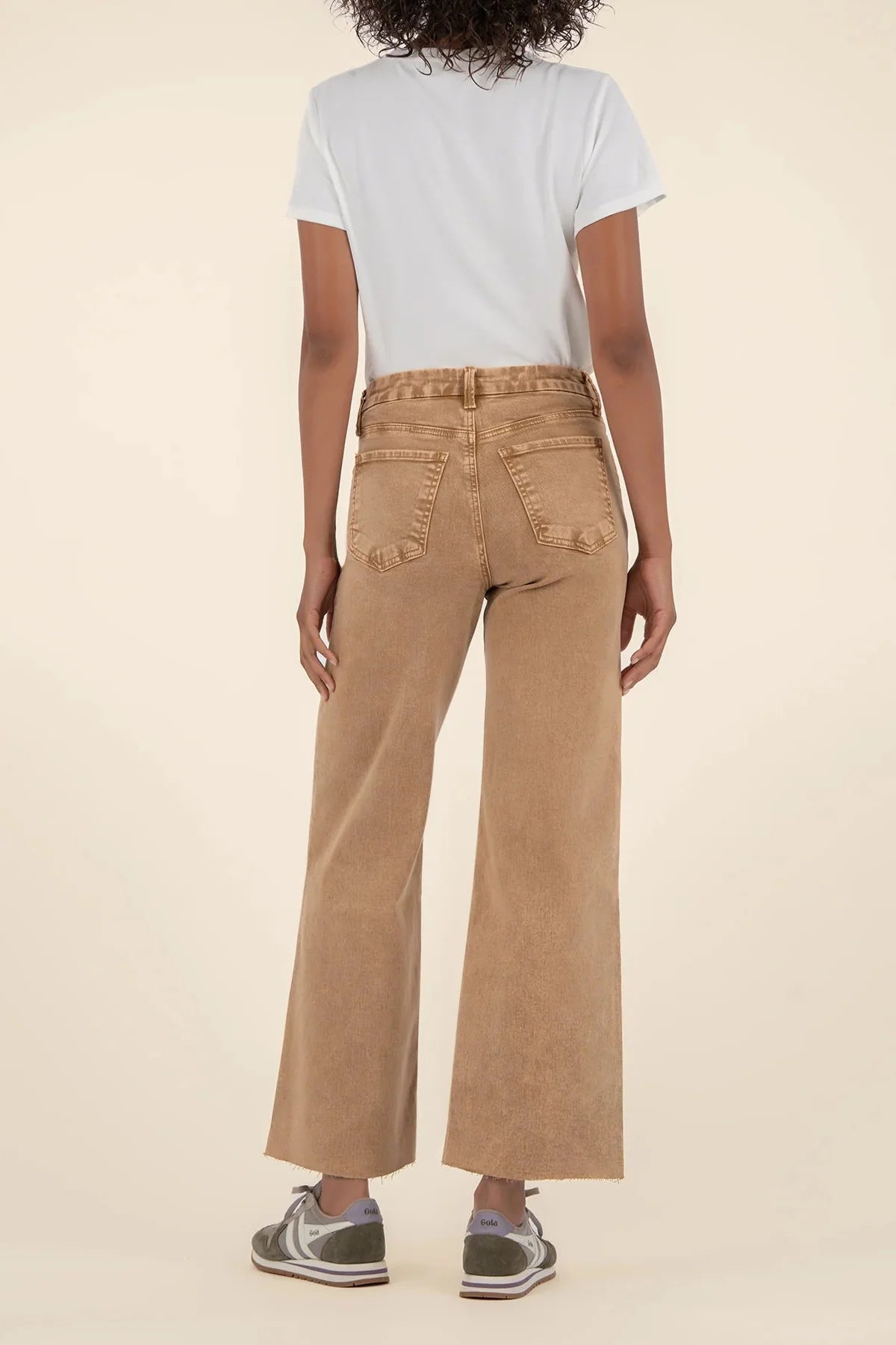 Back view of Person wearing a white t-shirt and Meg tan high-rise wide-leg jeans on a beige background