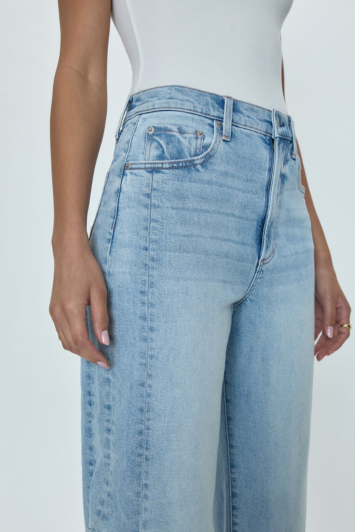 Pistola Eli High Rise Arched Leg jeans in "Sun Kissed," a pair of light blue denim jeans with a high waist, relaxed bowed leg, and slimming fade details.