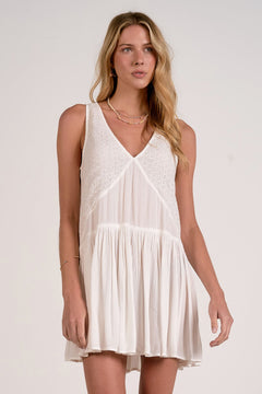 Woman wearing a white dress against a plain background