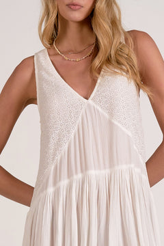 Woman wearing a white dress with a plain background