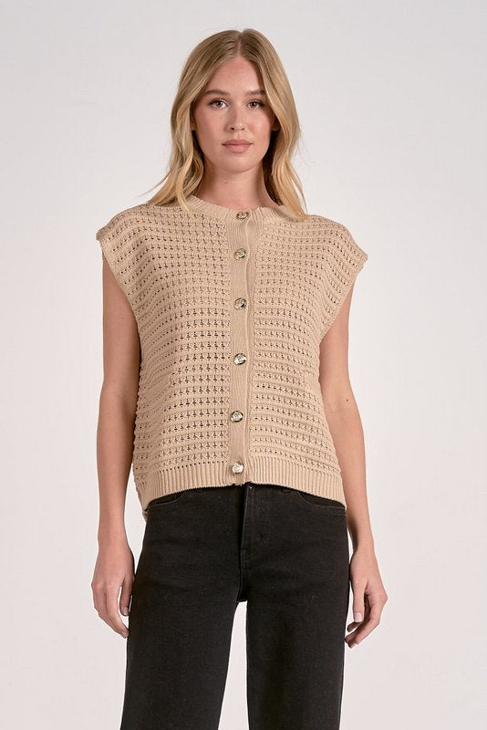Woman wearing a beige knitted vest on a white background