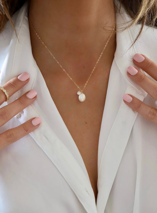 Pearl necklace worn by a person in a white outfit