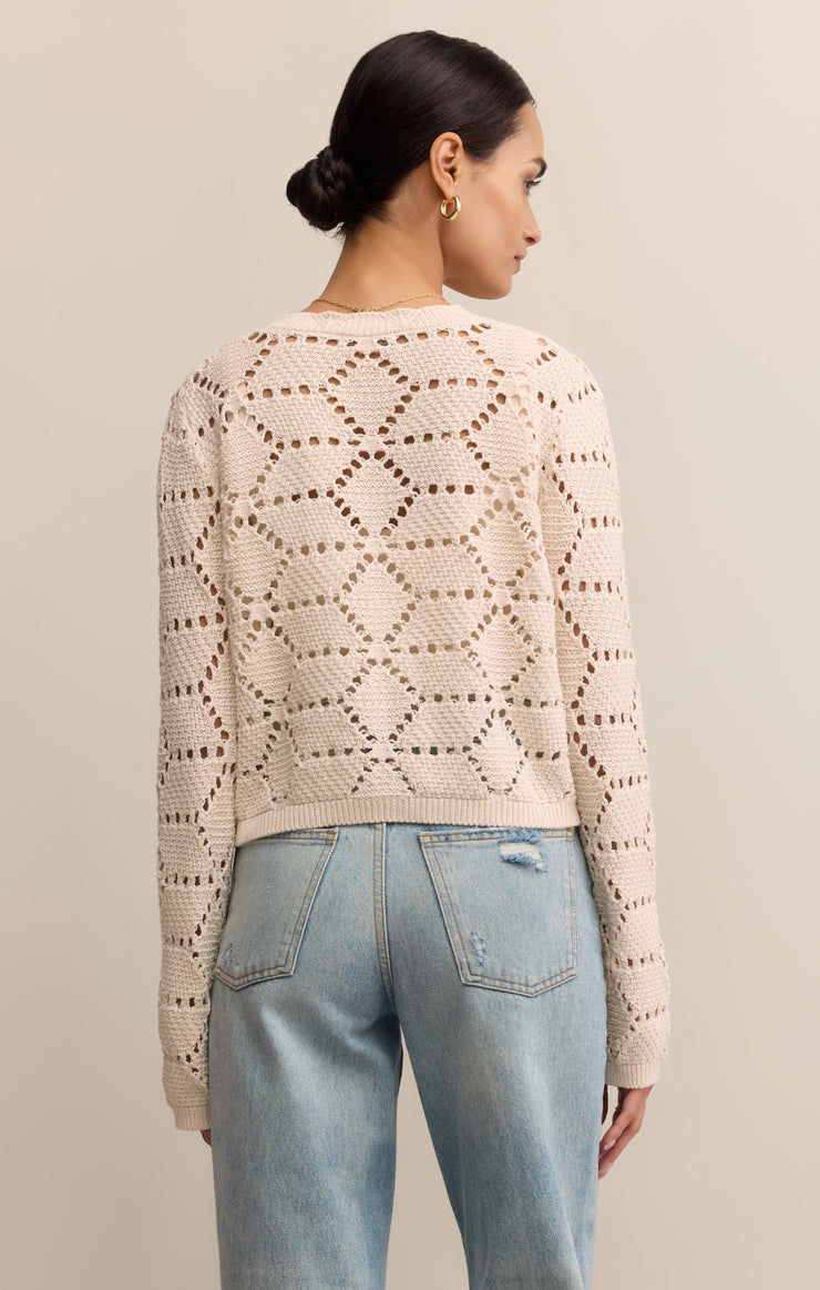 Back view woman wearing white crochet cotton button-up layered over cami with jeans