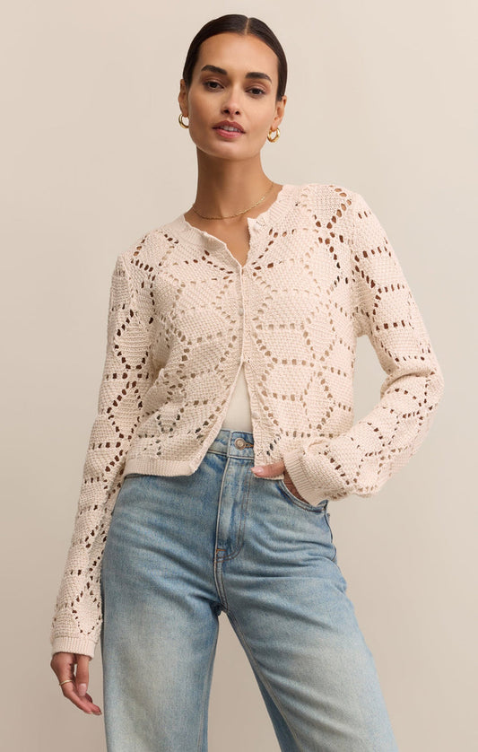 Woman wearing crochet cotton button-up layered over cami with jeans