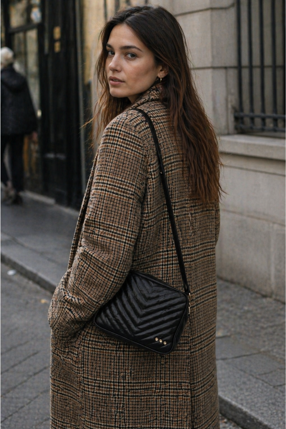 A woman on the street with a black quilted coco bag sold at rosiekarma.com