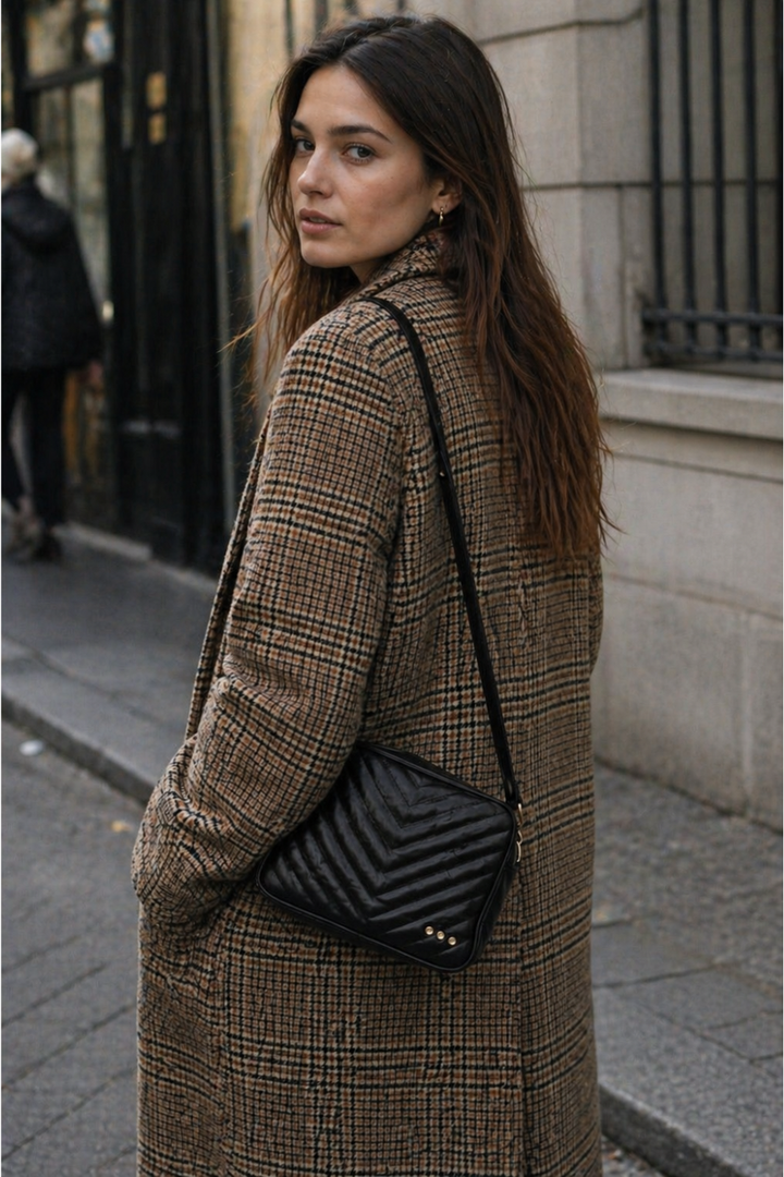 A woman on the street with a black quilted coco bag sold at rosiekarma.com