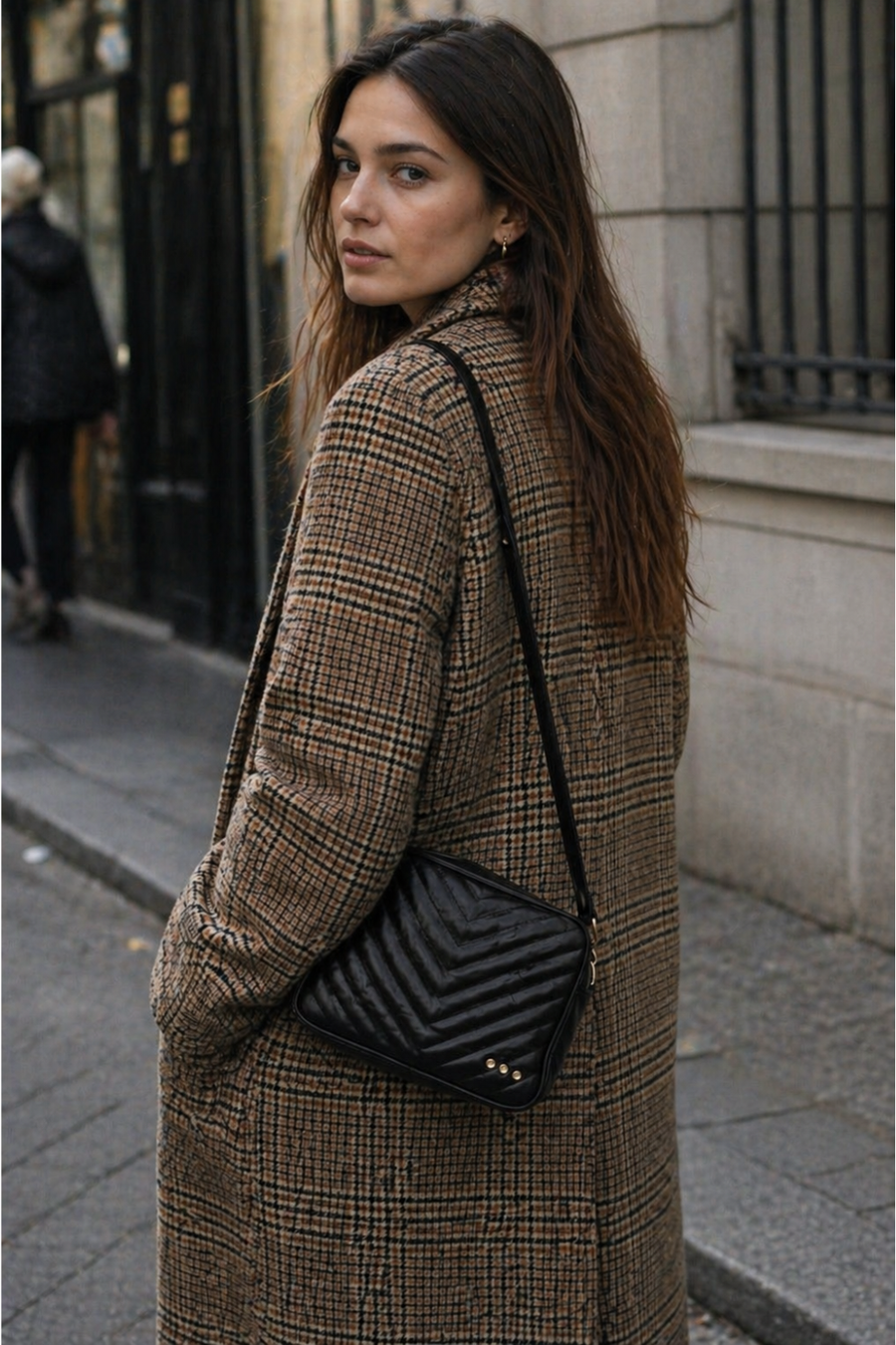 A woman on the street with a black quilted coco bag sold at rosiekarma.com