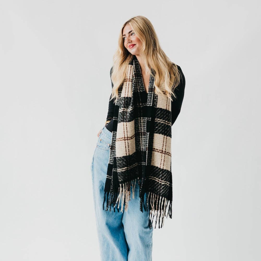 Woman wearing a black and beige plaid scarf on a white background