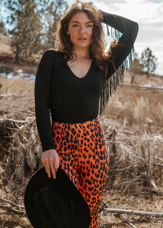 Sheer fringe bodysuit with dramatic fringe sleeves, plunging neckline, and cheeky cut – edgy night-out statement outfit for women