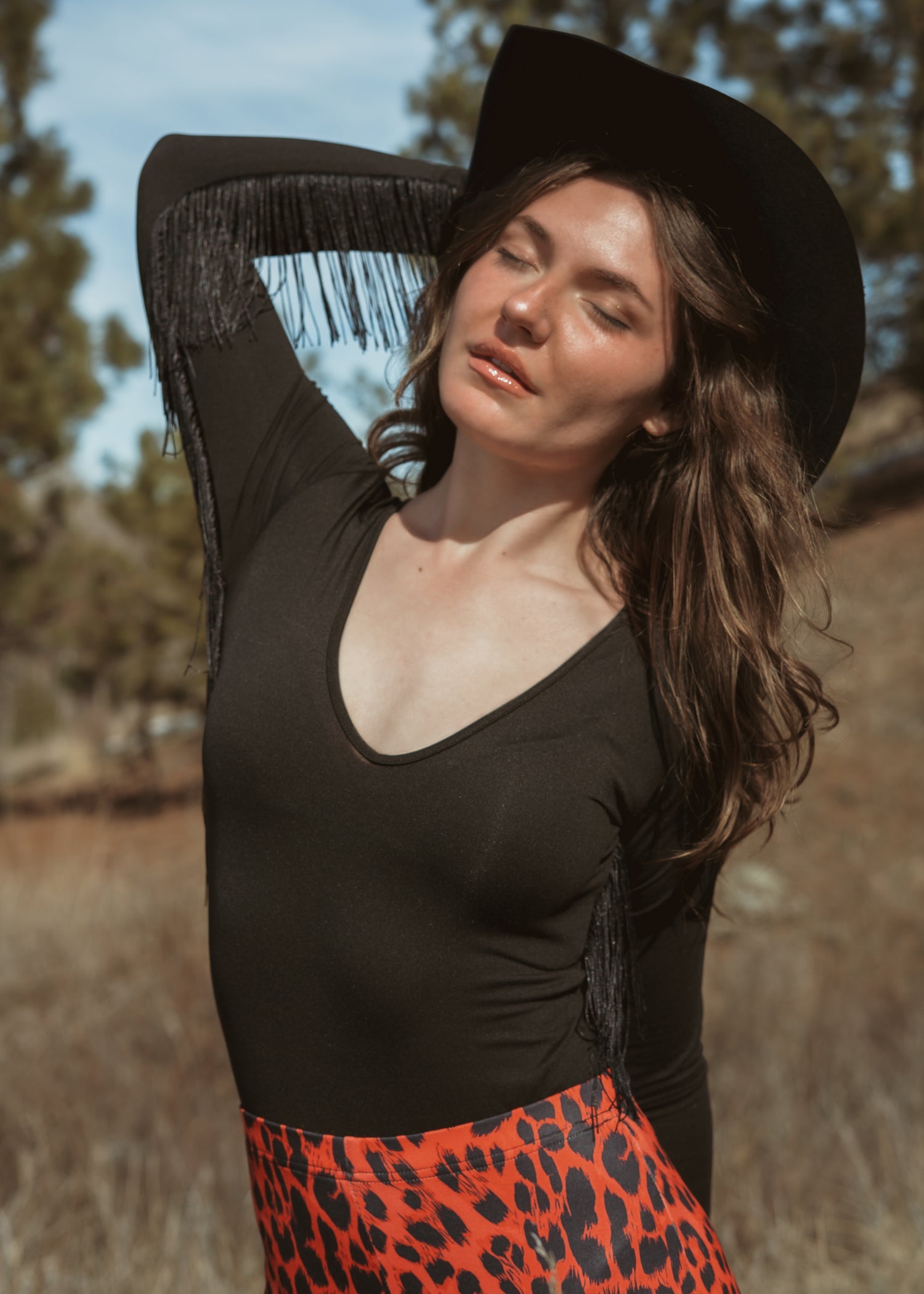 Sheer fringe bodysuit with dramatic fringe sleeves, plunging neckline, and cheeky cut – edgy night-out statement outfit for women