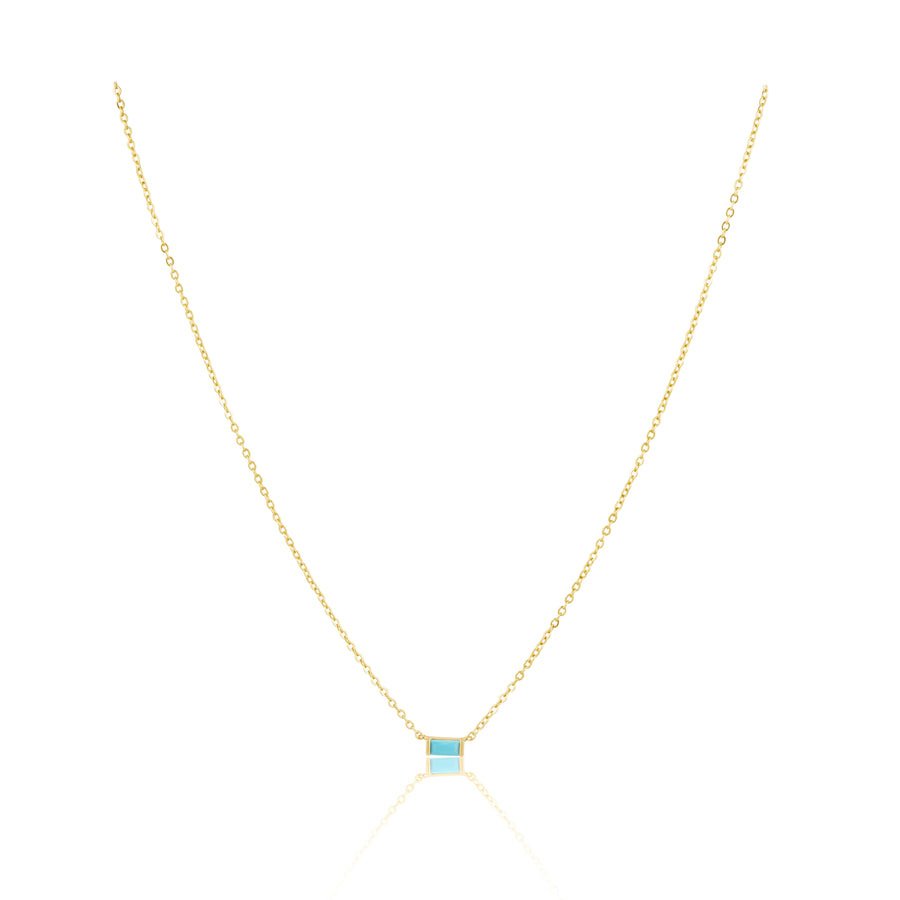 Gold necklace with a blue gemstone on a white background