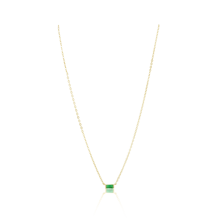 Gold necklace with a green gemstone pendant on a white background