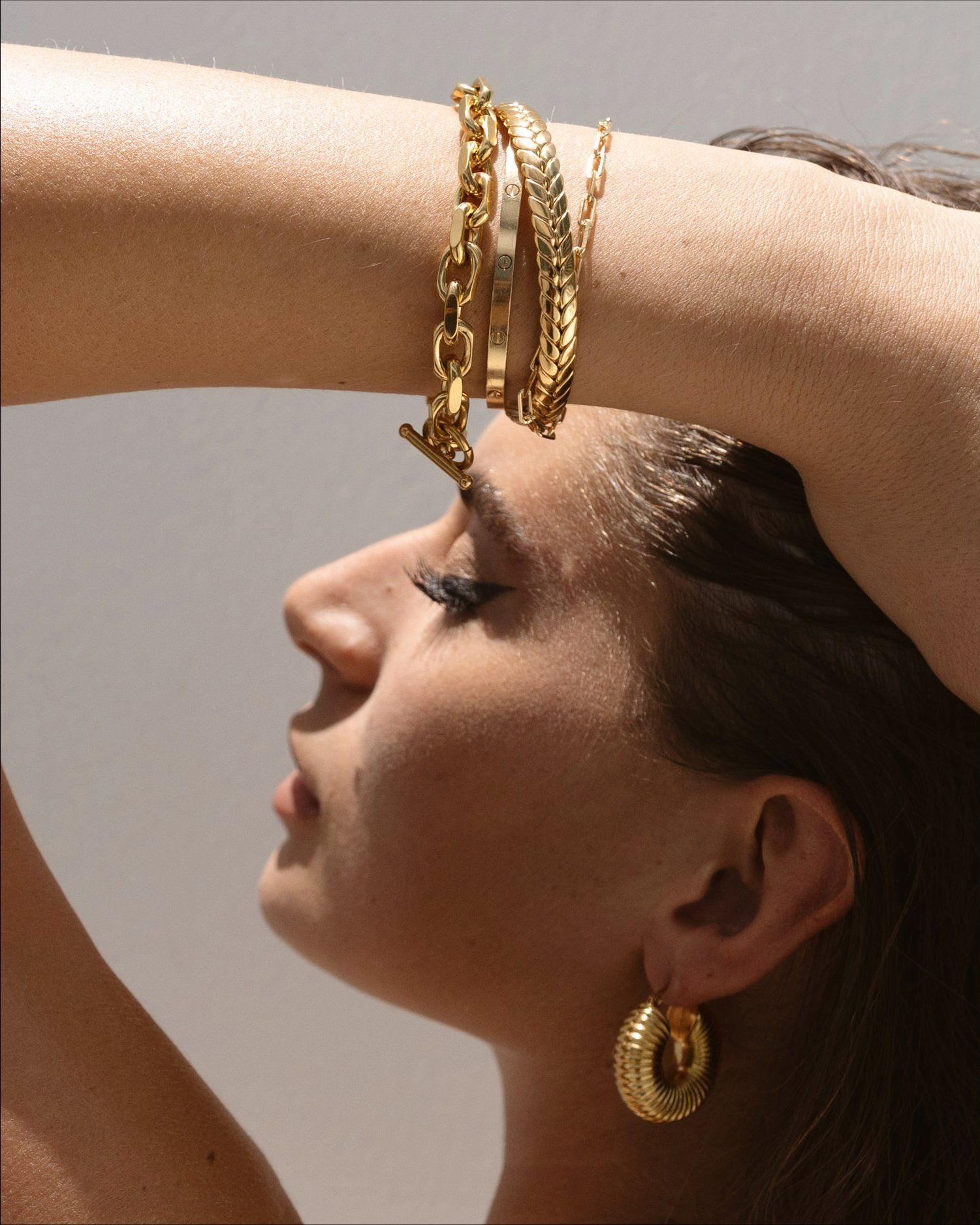 a women with gold bracelets and earring