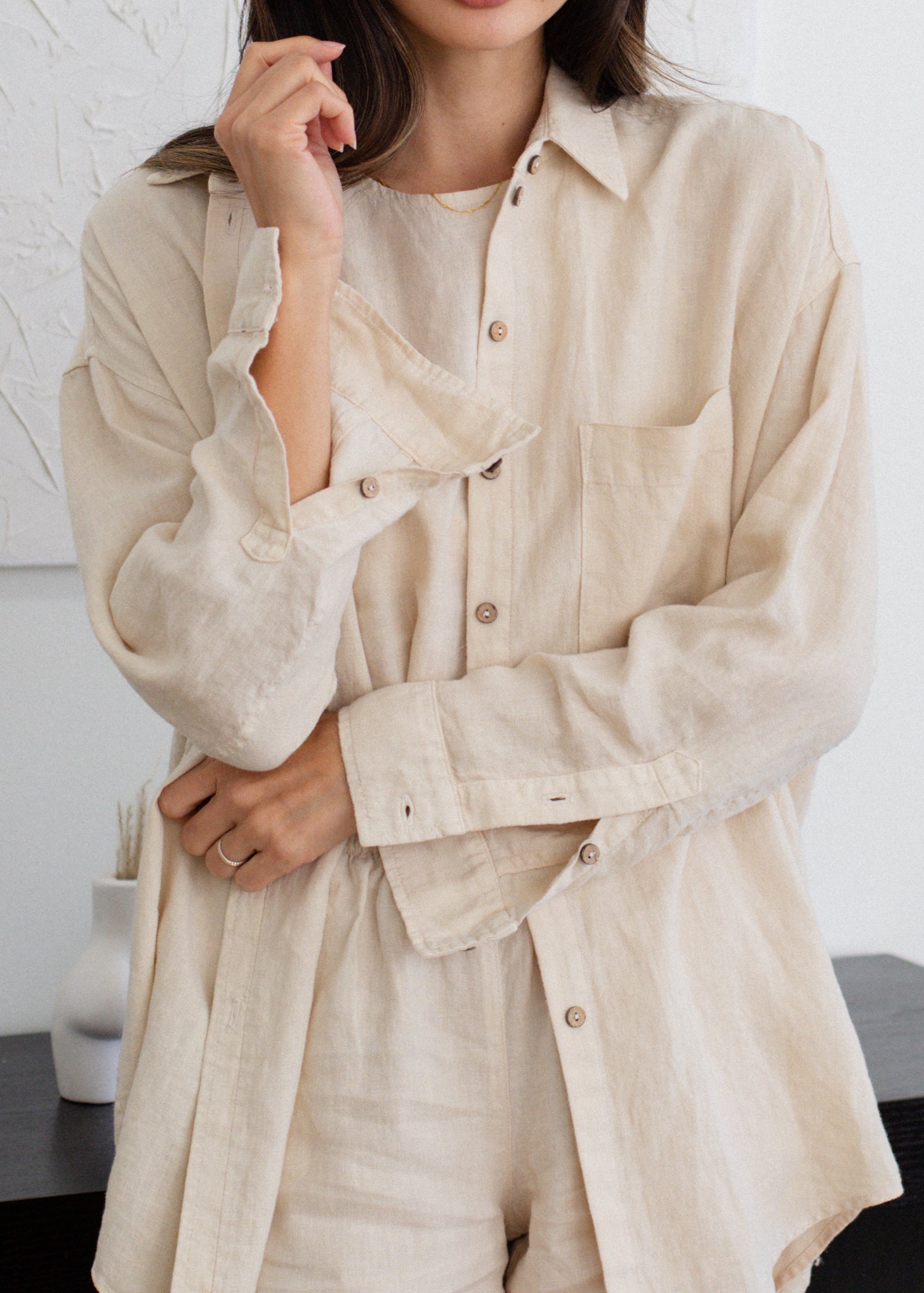 Person wearing a beige button-up shirt and pants against a white background
