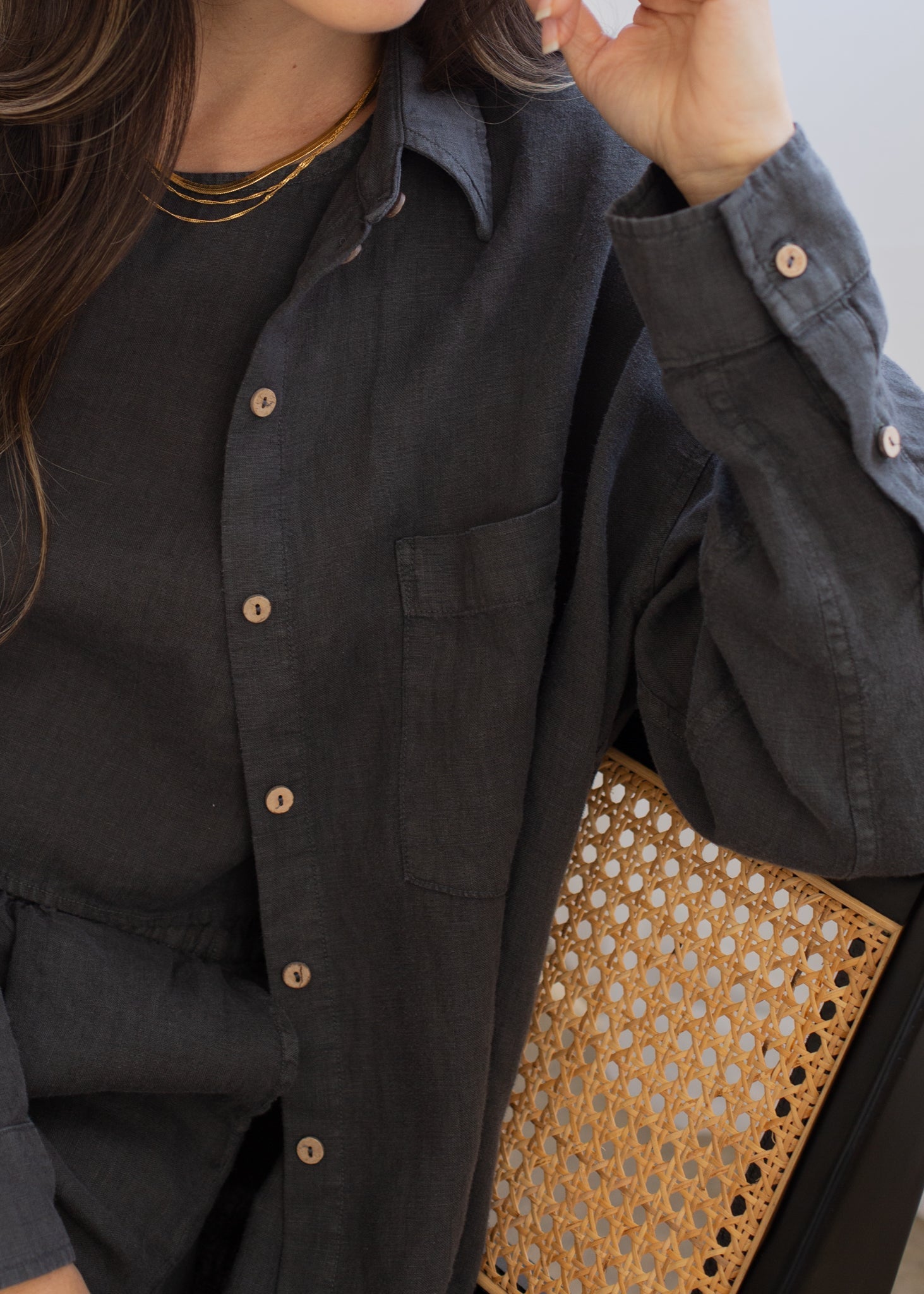 Person wearing a dark shirt with a patterned clutch