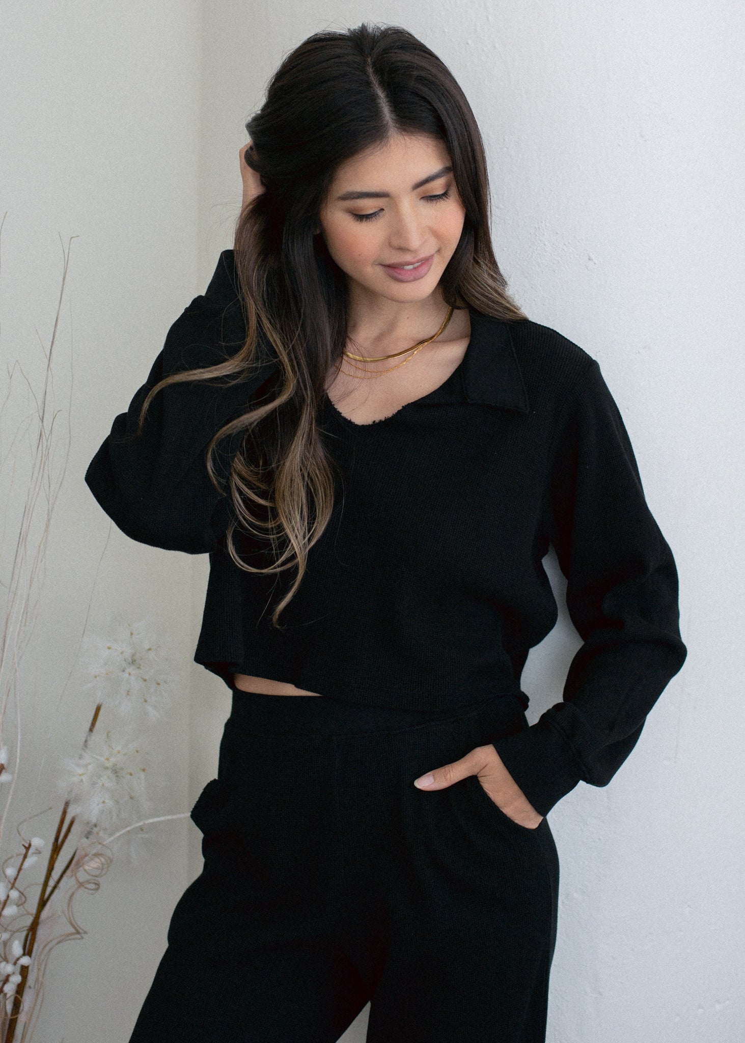 Woman wearing a black outfit against a white background