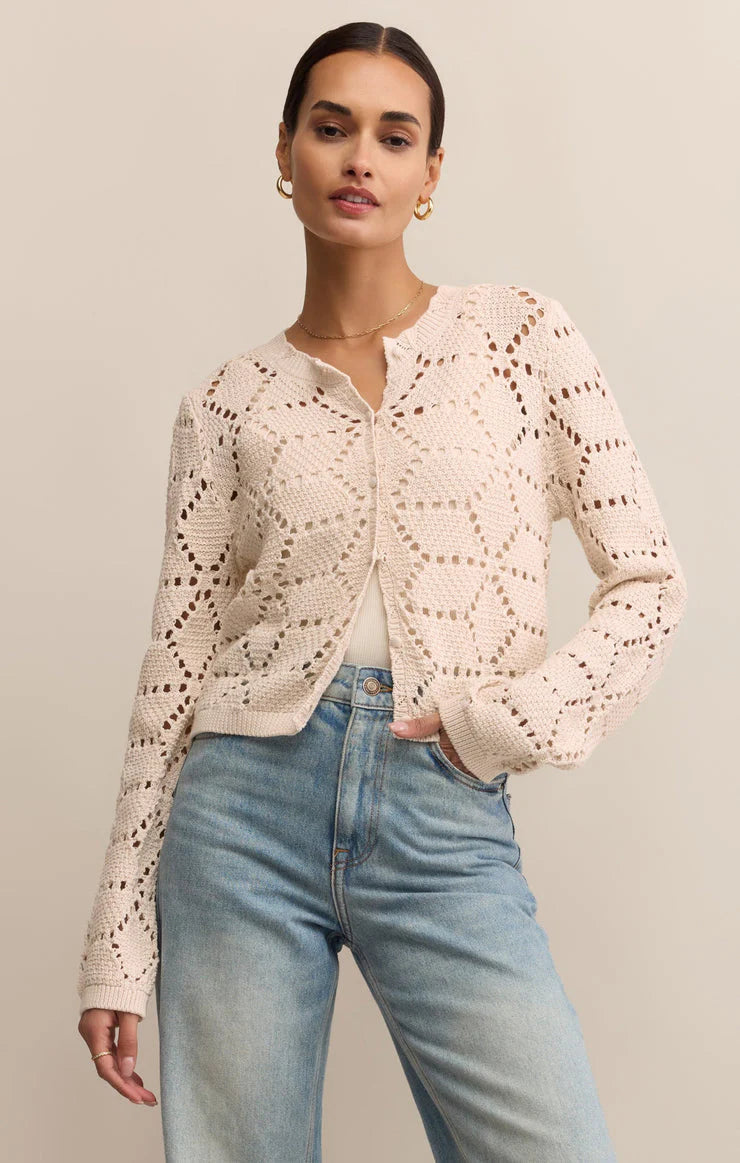 Women wearing cream colored cardigan and a pair of jeans.