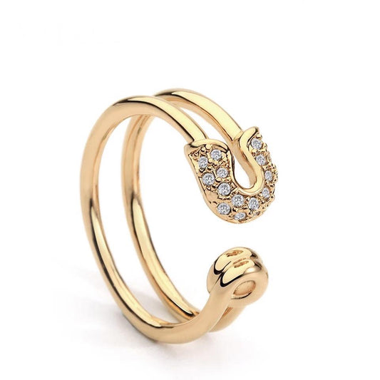 18k Gold Safety Pin Ring—a versatile, tarnish-resistant piece you can wear two ways: bold with the safety pin detail or sleek as a double-band ring. Hypoallergenic, durable, and effortlessly chic.