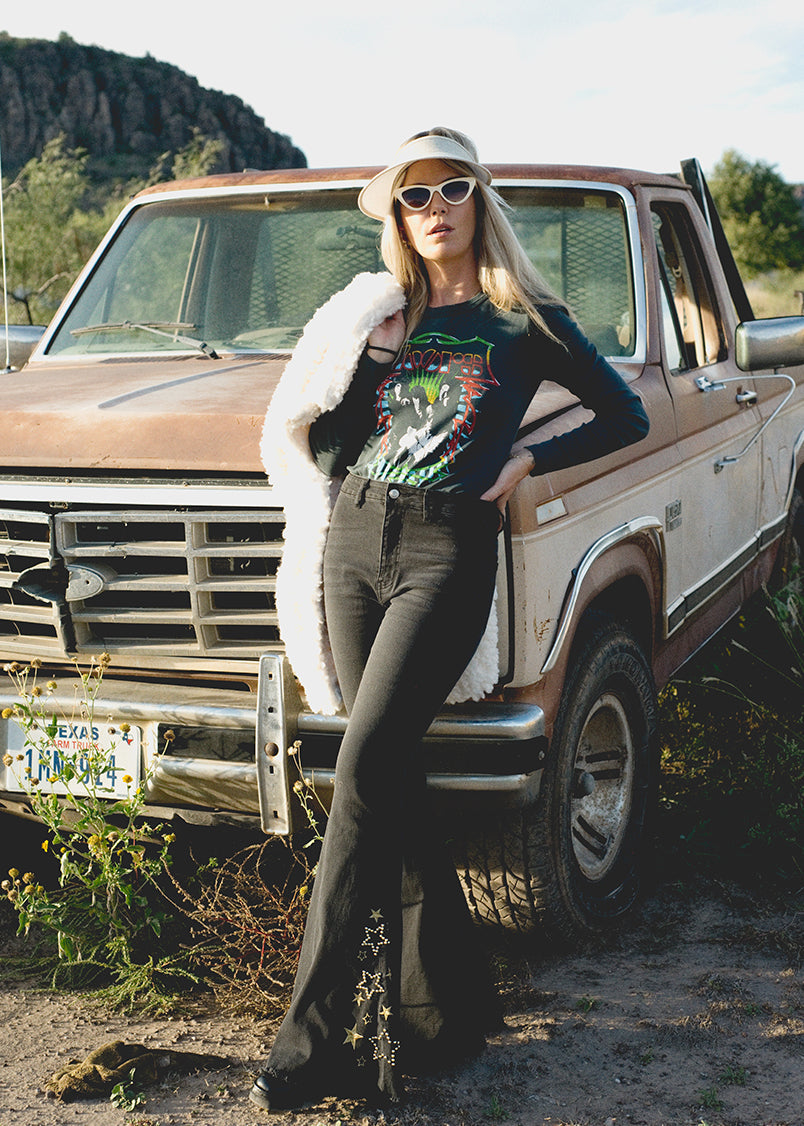 Person standing in front of a vintage truck wearing sunglasses and a hat.